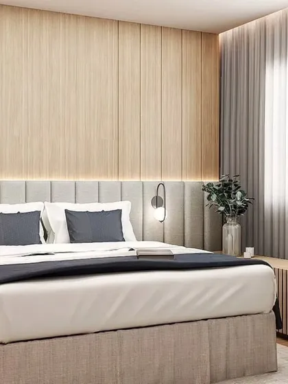 A full view of the bedroom, showing the wooden paneled wall and the comfortable bed. The design is simple, elegant, and timeless.
