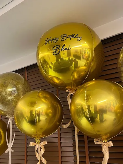 Personalization is key. A custom "Happy Birthday Bhai" message on a large gold balloon added a warm, personal touch to the sleek and modern birthday decor.
