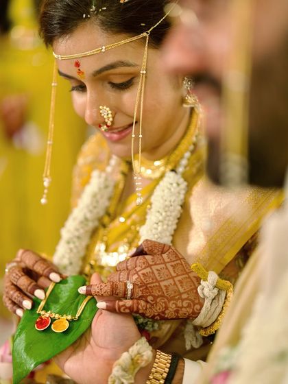 The intricate details of a wedding ceremony are where the story lives. This shot focuses on the bride's henna-adorned hands during a traditional Marathi ritual, capturing the beauty and symbolism of the moment.