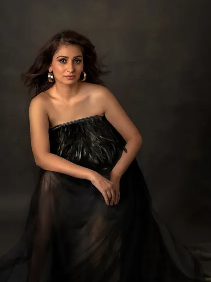 A closer portrait in the black feathered dress. The wind in her hair and her confident pose create a look that is both strong and graceful.