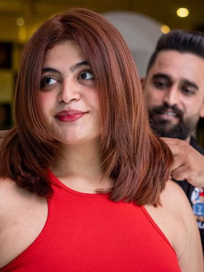 A beautiful auburn-red global colour that perfectly complements her skin tone. The fresh cut and styling enhance the richness of the new shade.