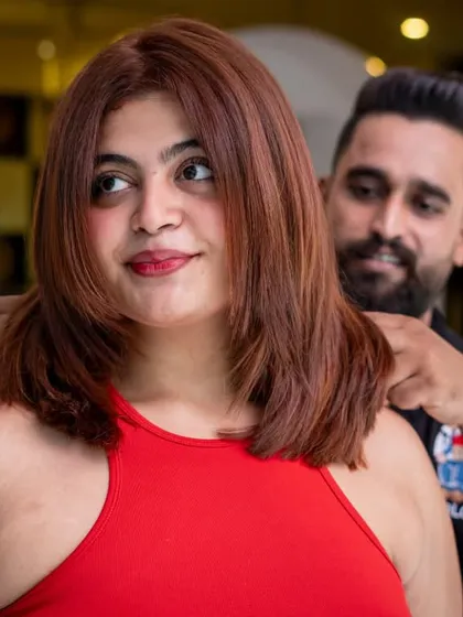 A beautiful auburn-red global colour that perfectly complements her skin tone. The fresh cut and styling enhance the richness of the new shade.