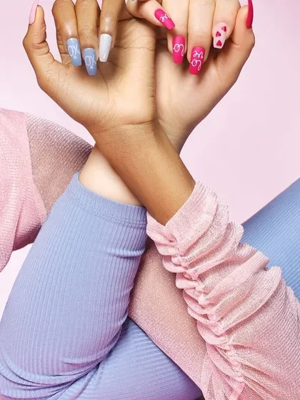 Two models' hands with playful pink and blue manicures. This shot is great for showing off multiple styles and promoting a sense of friendship and fun associated with the brand.