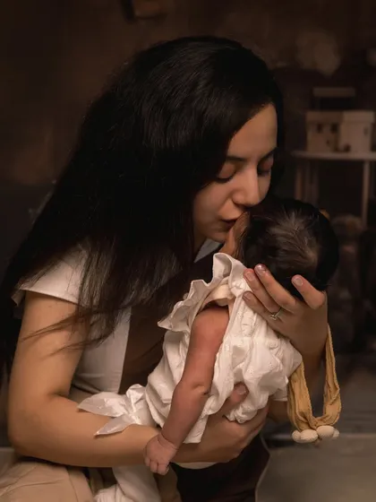 A mother's gentle kiss for her newborn. These are the quiet, heartfelt interactions that I aim to preserve, creating timeless images of maternal love.