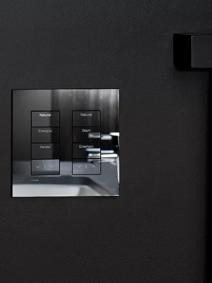 This architectural glass finish Palladiom keypad by Lutron is an elegant choice for dark, modern walls. The reflective surface and clean lines provide sophisticated control for lighting scenes like 'Energize', 'Glam', and 'Entertain'.