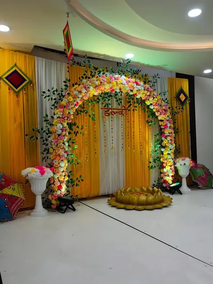A wider angle of the Haldi setup, showing the placement of traditional Rajasthani umbrellas and decorative wall hangings that complete the theme.