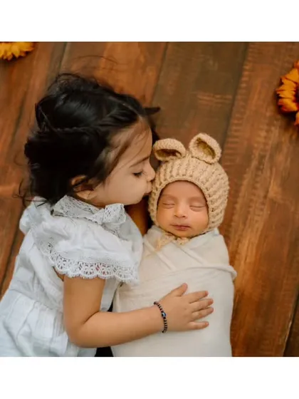 A gentle kiss for her new baby brother. This is the kind of heartwarming, unscripted moment that tells a beautiful story of sibling love.
