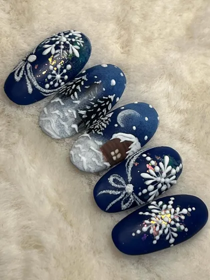 A snowy Christmas scene painted across a set of five nails. This landscape art includes a cozy cabin, snow-covered trees, and sparkling snowflakes.