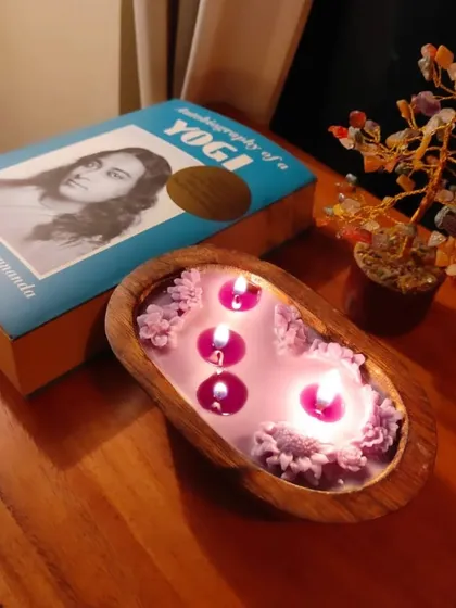 My wooden tub candle, lit and glowing, sits beside the "Autobiography of a Yogi." It’s the perfect companion for quiet evenings of reading and reflection, filling the space with a calming fragrance.
