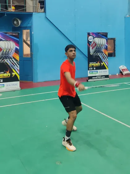 An athlete in perfect form, preparing for an overhead shot. Our training emphasizes correct posture and footwork as the foundation for powerful and accurate strokes.