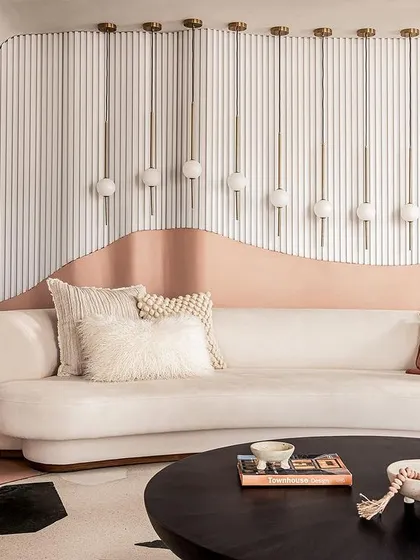 The living room wall features a wave of custom lighting fixtures that follow the curve of the sofa, adding a layer of soft, ambient light.