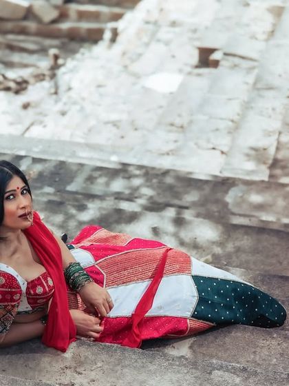 A unique and alluring pose, lying on the stone steps. This shot is artistic and unconventional, blending fashion with a raw, historical setting.