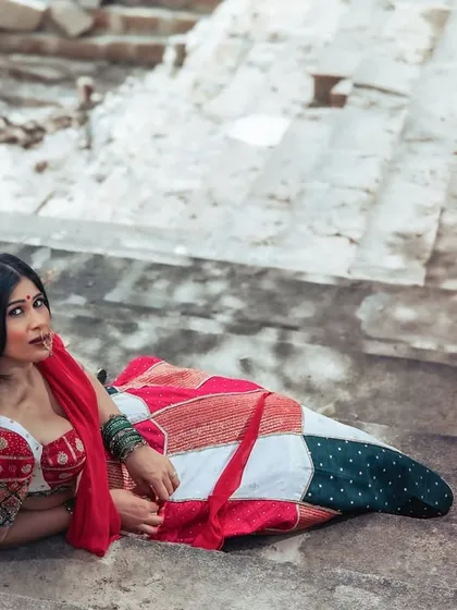 A unique and alluring pose, lying on the stone steps. This shot is artistic and unconventional, blending fashion with a raw, historical setting.