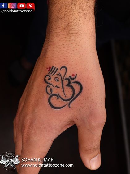 A minimalist Ganesha and Om symbol fusion, perfectly placed on the hand. This small tattoo is a great example of a subtle yet powerful expression of faith.