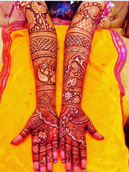 A beautiful design with a mix of peacock and elephant motifs. The patterns flow gracefully from the arms down to the fingertips.