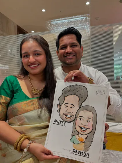 A smiling couple holds up their finished caricature, a fun and artistic keepsake from the wedding festivities.