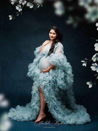 Framed by delicate floral illustrations, this portrait in a voluminous blue ruffled gown looks like a page from a fairytale.