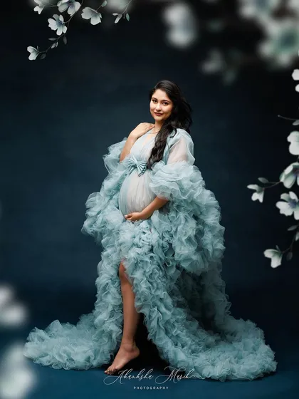 Framed by delicate floral illustrations, this portrait in a voluminous blue ruffled gown looks like a page from a fairytale.