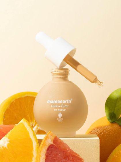 We surrounded this CC serum with its key citrus ingredients to create a fresh and vibrant composition. The dropper is lifted, showing the product's color and texture, ready to be used.