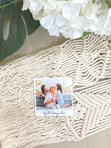 A custom fridge magnet featuring a photo of a grandmother with her grandchildren and the caption 'World's best grandma'. A sweet and simple gift for just ₹350.