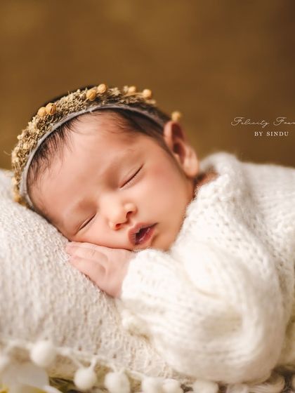 Every detail is precious. This close-up shot focuses on the serene expression of a sleeping newborn, a beautiful memory of their first days.