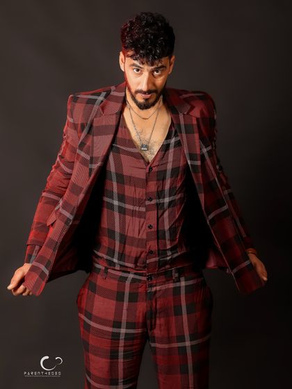 A confident pose that showcases the full suit in a dynamic way. The open jacket adds a sense of movement and style.