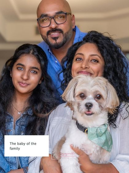 The complete family portrait with Milo, the baby of the family, held lovingly. Everyone's relaxed smiles show a happy, connected family unit.