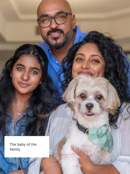 The complete family portrait with Milo, the baby of the family, held lovingly. Everyone's relaxed smiles show a happy, connected family unit.