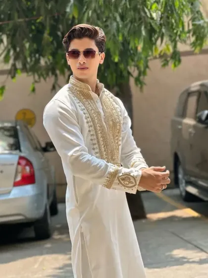 A side view of the white and gold kurta, showing the sleeve embroidery.