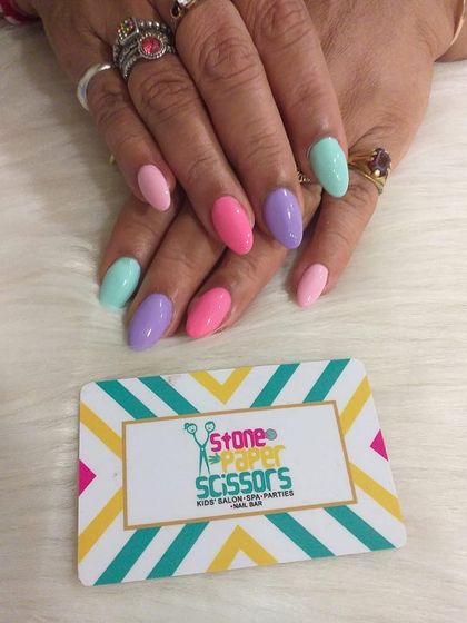 A full pastel rainbow on your fingertips. Each nail is painted a different soft shade, including mint green, baby pink, and lavender, for a happy and colorful manicure.