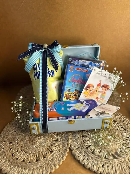 This kids' Rakhi hamper comes in a mini trunk box, filled with popcorn, coloring books, and other fun surprises to make your little brother's day.
