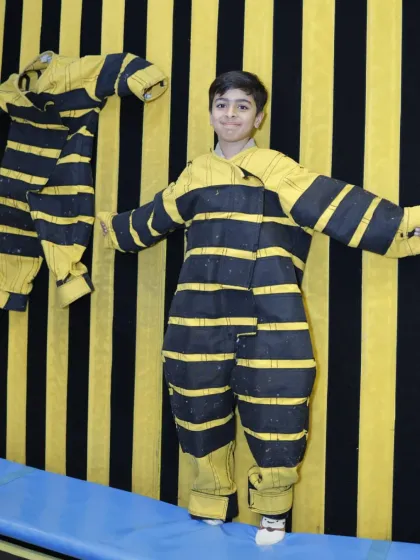 A young adventurer balances carefully before taking on the sticky wall challenge.
