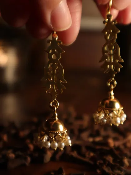 Let the light catch you mid-moment with these traditional jhumkas. Made of sterling silver with gold plating and pearls, they sway with grace and playfulness.