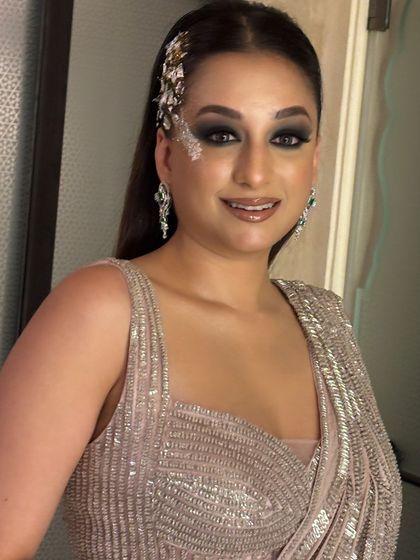 A smiling portrait of the client with her glamorous side-tuck and waves. This shows how a hairstyle can be both edgy and beautiful, perfect for a confident client.