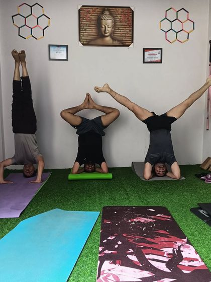 Everyone's headstand looks a little different, and that's okay. Here you can see three students exploring their own unique variations of the pose.