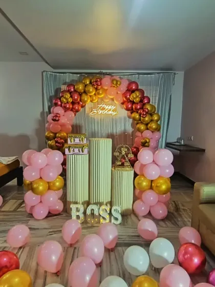 Here is a birthday setup we did at the Ashoka Grand hotel in Shivamogga. The red, pink, and gold balloon arch and the 'BOSS' light-up letters show how we can customize decor for any personality.