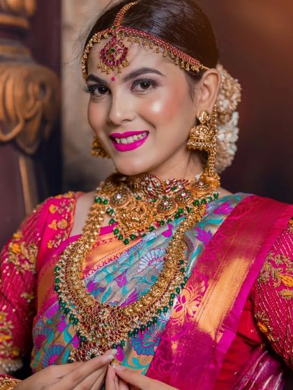 A classic beauty shot focusing on the model's smile and the stunning, colourful jewellery set.