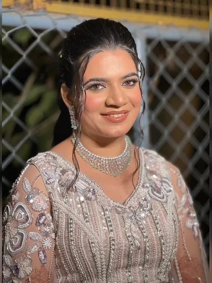 A close-up of the bride's wet-look hairstyle and shimmery makeup, a trendy choice for a sangeet night.