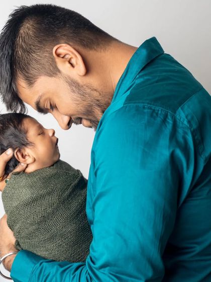 A father's love. This tender moment between a new dad and his sleeping baby captures the profound connection and emotion of early fatherhood.