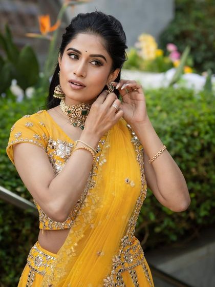 A candid moment from a Mehendi shoot. The makeup is fresh and bright, perfect for a sunny outdoor event, and pairs beautifully with her yellow lehenga.