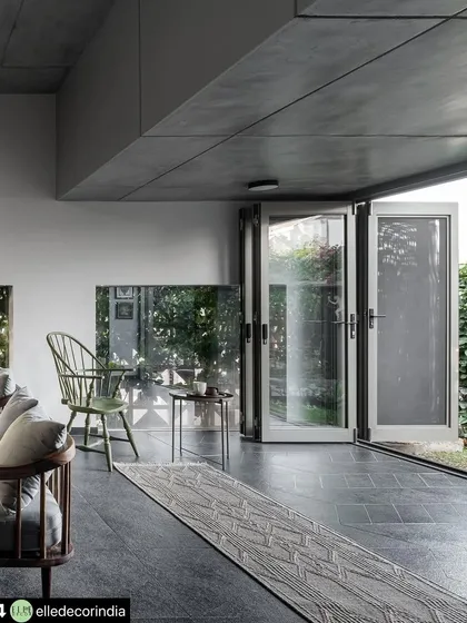 Simple, clean-lined doors fold away to completely open the living area to the front garden. This design choice is fundamental to our indoor-outdoor philosophy, allowing fresh air and the sounds of nature to become part of the home's atmosphere.