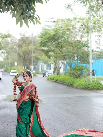 A wide shot showing the bride on a quiet street, her vibrant traditional attire creating a beautiful contrast with the modern setting.