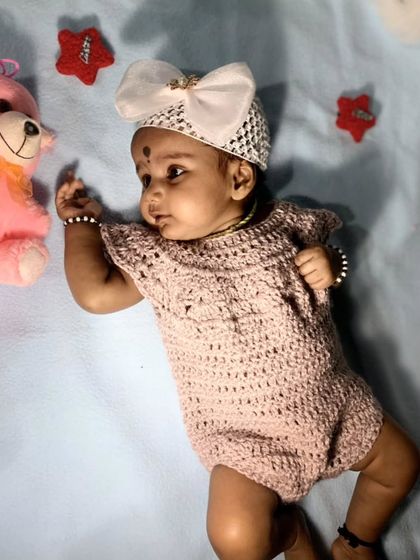 This sweet baby girl is wearing a custom crochet romper I made. The delicate stitch pattern and cap sleeves make it a lovely and comfortable piece for portraits or special family events.