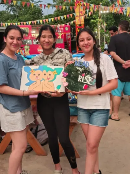 A group of friends shows off their finished canvases after an outdoor painting session at our Punjabi Bagh location.