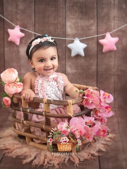 Look at that big, happy smile. This setup with a rustic basket and a star garland is perfect for a sitter session. Her joy is just contagious.