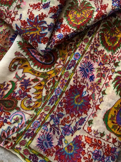 This image highlights the border of the dupatta, where traditional paisley designs are rendered in a vibrant and joyful color palette.