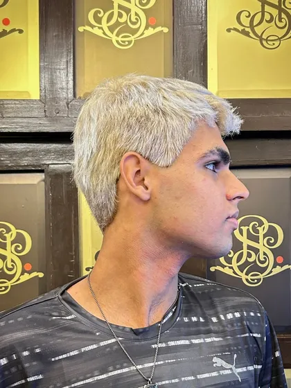 A side profile of the men's platinum blonde makeover. Achieving this clean, even tone requires skill and precision, especially on dark hair.
