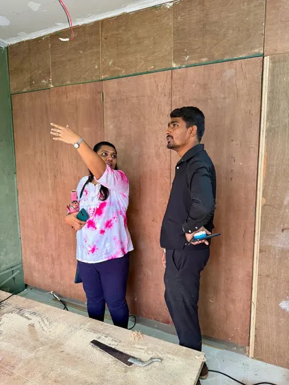 Discussing the wardrobe layout with a client in front of the base plywood structure. This is where we finalize heights and compartments.