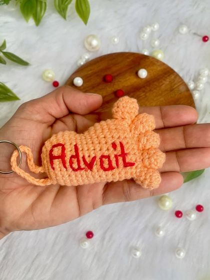 Holding a personalized baby foot keychain for a little one named Advait. It's a sweet memento for new moms and dads.