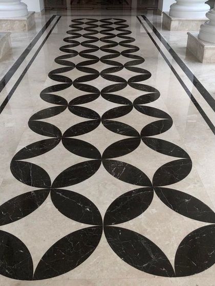 Detail of the custom marble inlay flooring in a hallway. The geometric pattern, created with black and white marble, guides the eye and adds a layer of sophisticated, graphic detail to the space.